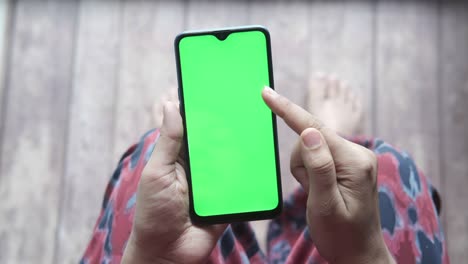 vista superior de mujeres con la mano sosteniendo un teléfono inteligente sentadas en una silla