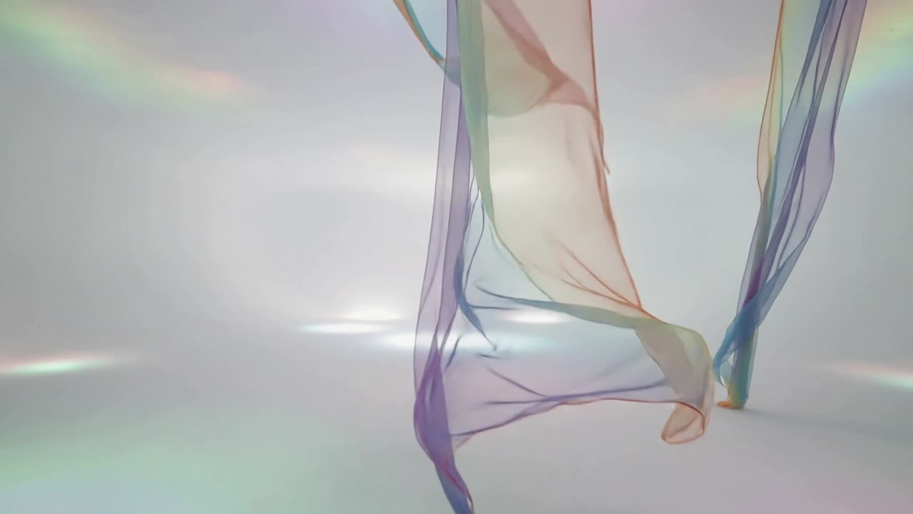 Descending sheer fabric panels sweeping to floor in studio, breeze creating pastel overlaps