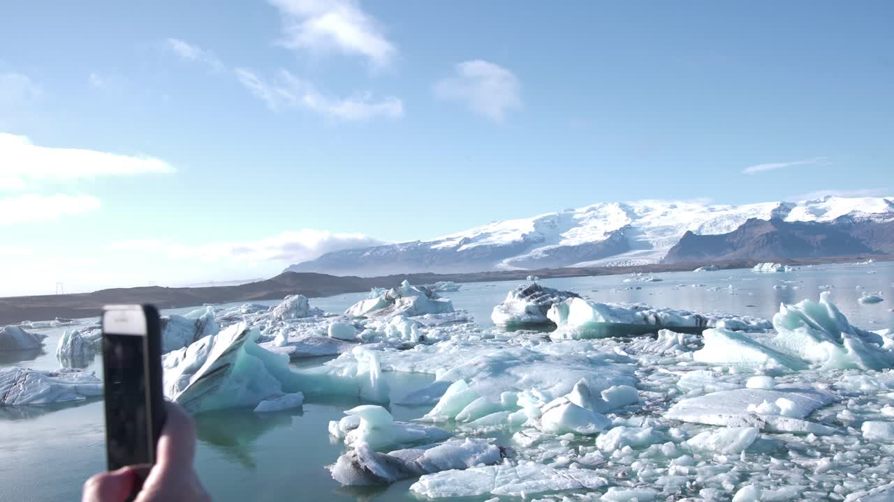 빙원과 산, 아이슬란드가있는 호수 사진을 찍는 휴대 전화