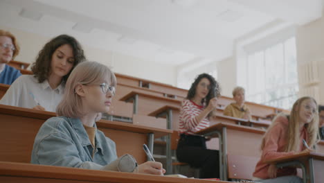 students taking notes in a lecture hall