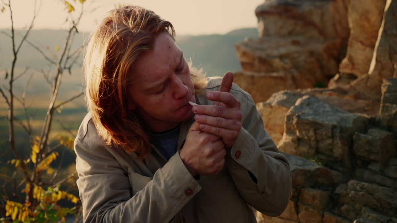 escursionista esperto che riposa mentre accende la sigaretta e si mette il cappello, vogelberg