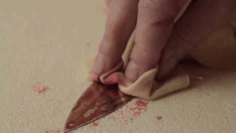 mano ensangrentada del asesino criminal que limpia la sangre de un cuchillo después de apuñalar