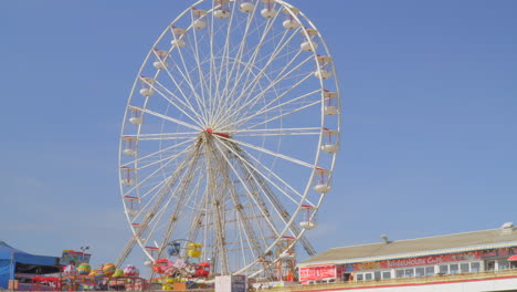 big wheel on pier spinning in sunlight with stops and starts