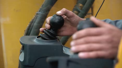 hands operating construction vehicle controls