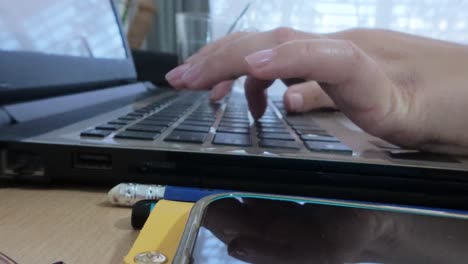 front view of hands typing on a laptop, engaged in writing or creating digital content