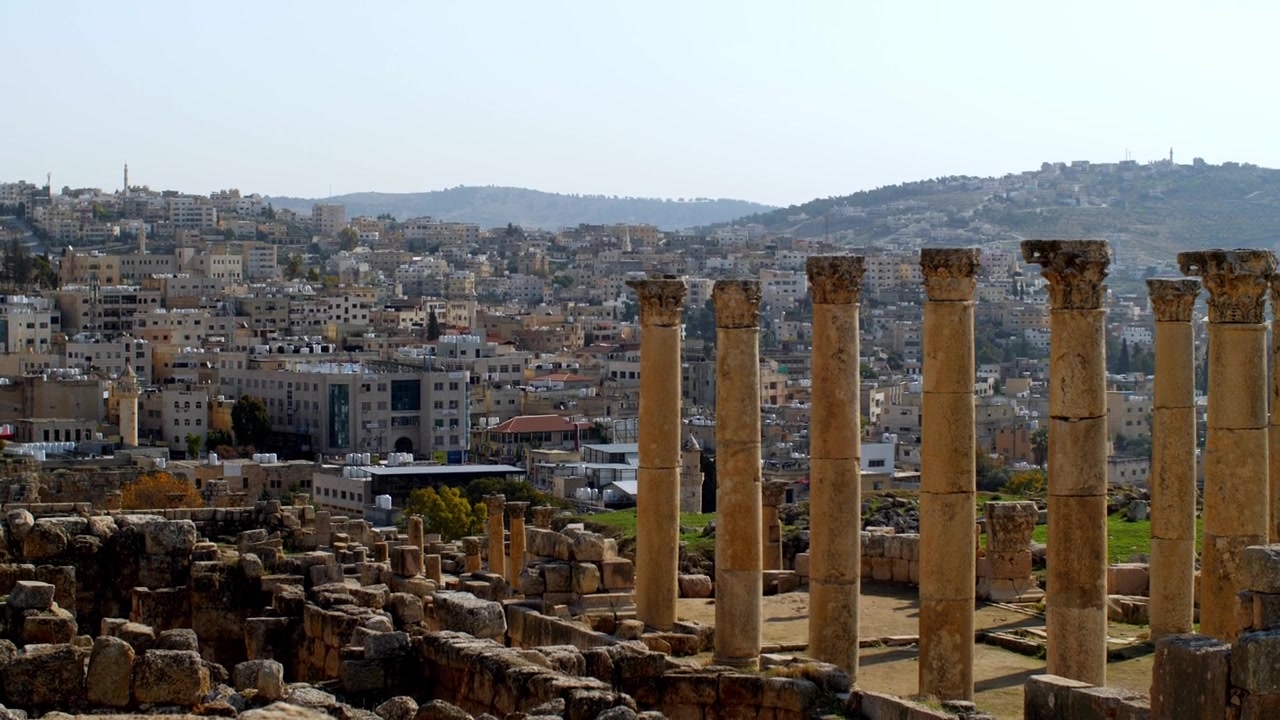 Ürdün, Orta Doğu'da, sıcak bir gün batımında şehir manzarası eşliğinde Amman Kalesi'nin antik Roma kalıntıları. Tarihi sütunlar, arkeoloji alanı, miras mimarisi ve ünlü bir simge yapı.