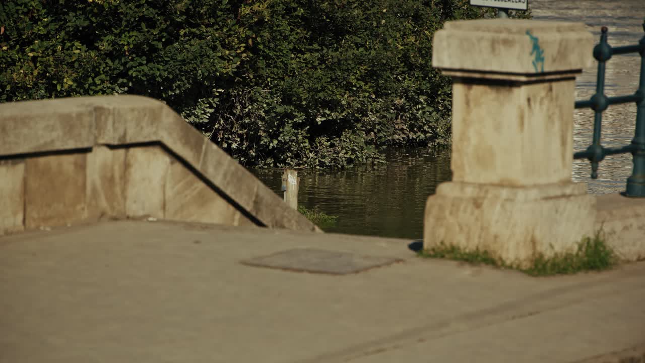 Old stone steps leading to a flooded riverside with greenery and railing, Budapest, Hungary