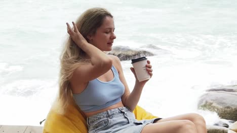 mujer disfrutando de café en la playa