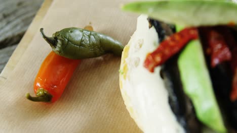 chili peppers and burger on wax paper