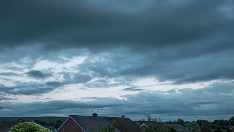 fast moving low level cloud time-lapse at dusk above some suburban houses and trees in the north west of the uk