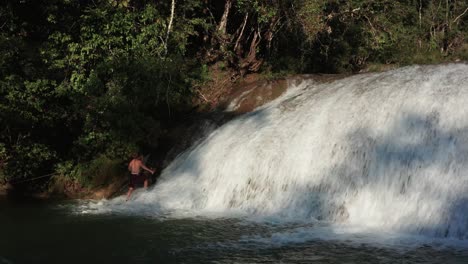 A-man-climbs-a-fast-flowing-waterfall-in-mexico
