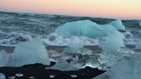 icebergs and ice blocks on the black sand on the shore in iceland