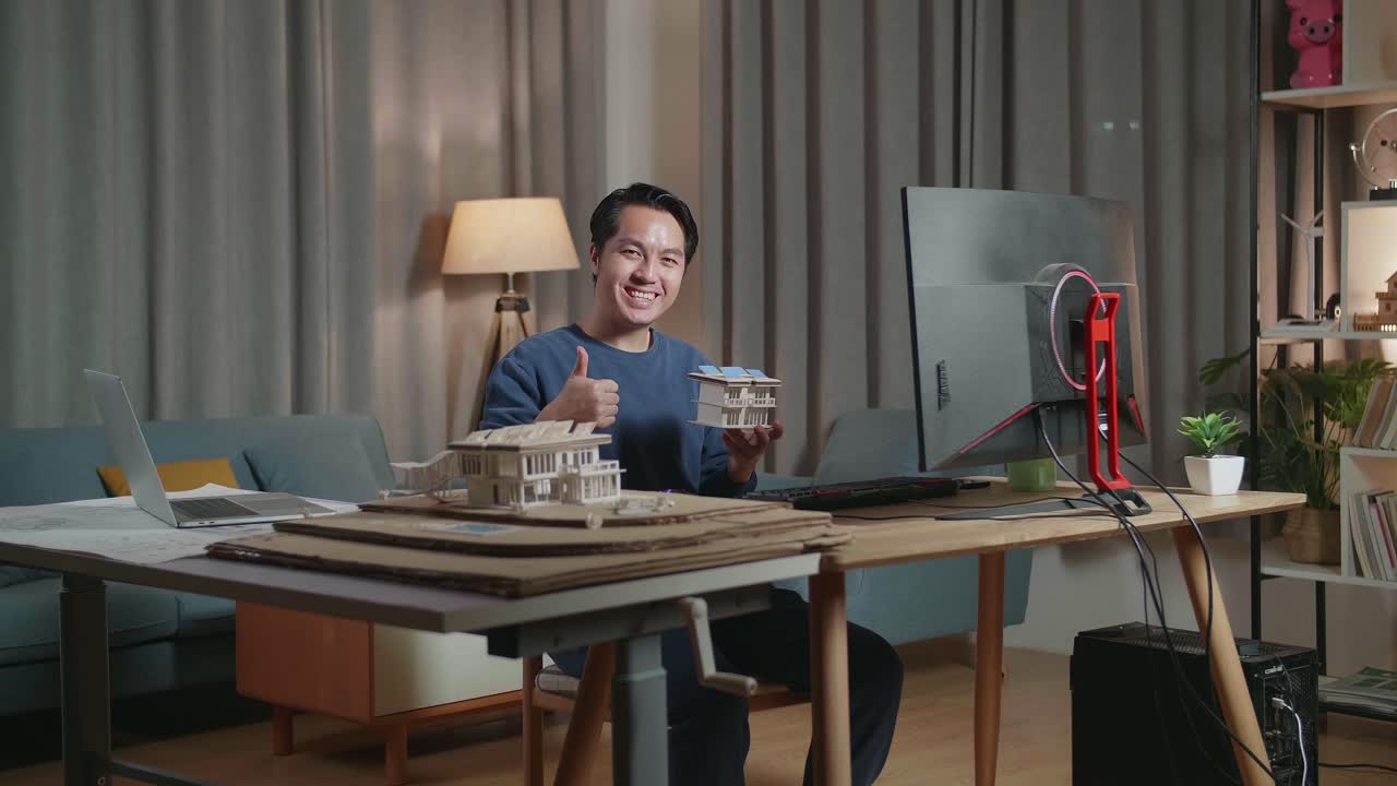 Architetto sorridente che mostra il modello di una casa