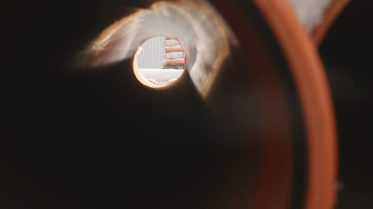 Orange PVC pipes stacked in construction site