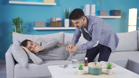 hijo adulto cuidando a su padre enfermo en casa.