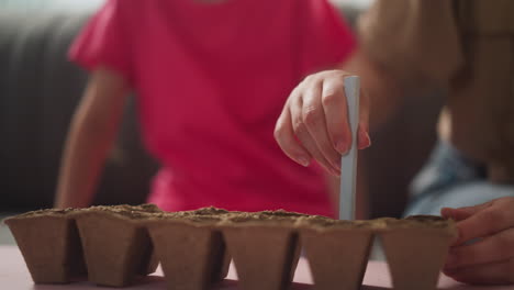 Madre-E-Hija-En-La-Habitación,-La-Mano-De-Una-Joven-Hace-Agujeros