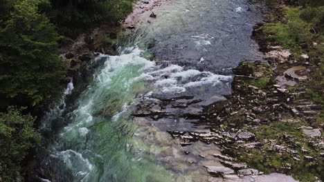 Wild-river-with-a-small-waterfall-and-crystal-clear-water,-drone-flight