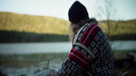 long-haired norwegian guy drinking coffee outdoor with nature background