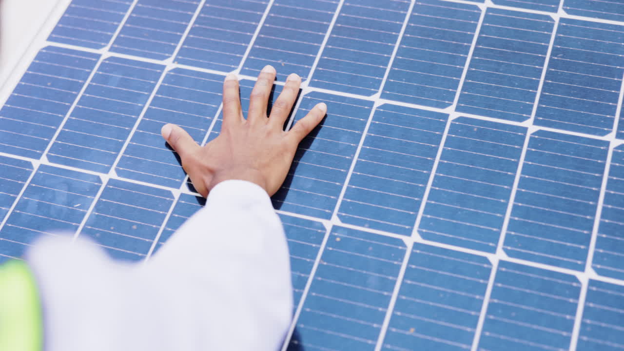 클로즈업, 손과 남자가 태양 패널을 확인하고 있습니다.