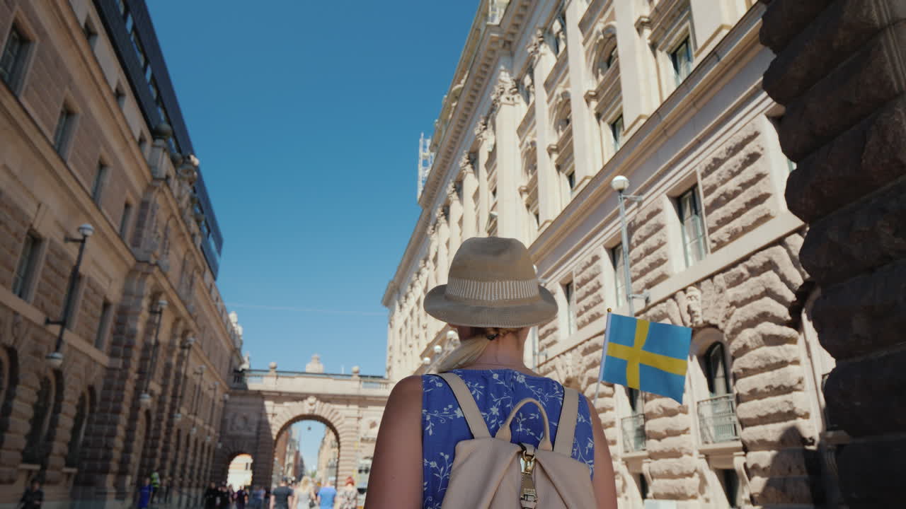 스칸디나비아 공동의 스톡홀름 관광에서 의회 근처의 유명한 아치를 걷는 관광객