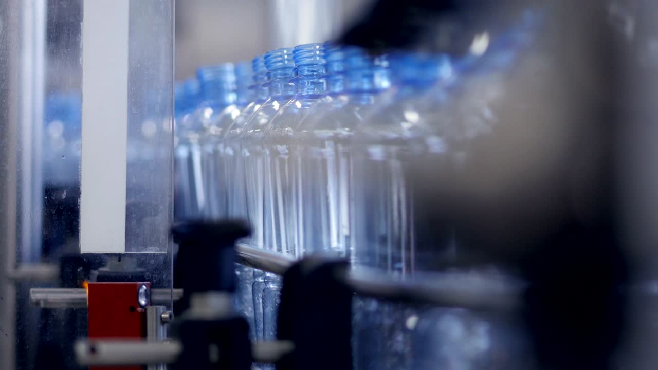 botellas de mascotas vacías moviéndose a lo largo de una cinta transportadora.