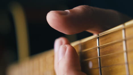 skilled guitarist holds brown acoustic guitar in hands