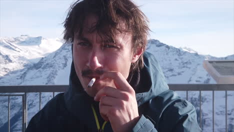 skier smokes a cigarette at a break high in the mountains