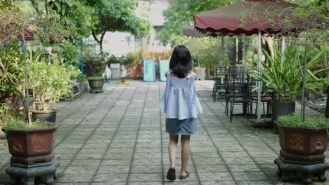 Girl Walking Through a Garden Patio