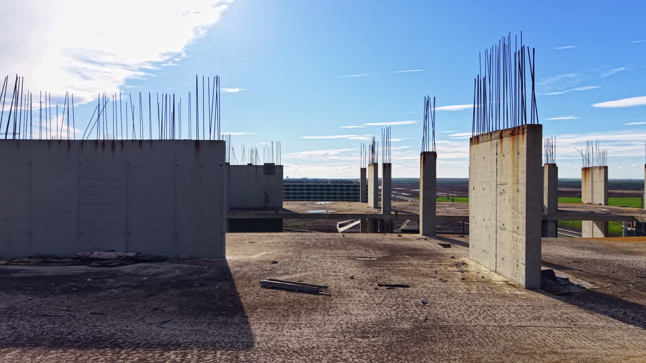 Urban landscape of abandoned construction site under a bright blue sky with scattered clouds at midday