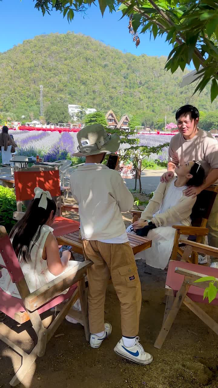 ครอบครัวชาวเอเชียที่มีความสุขกำลังถ่ายรูปด้วยกันที่สวนดอกไม้บนภูเขาที่สวยงามในประเทศไทย