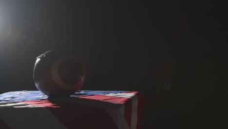 low key lighting studio shot of american football on stars and stripes flag 4