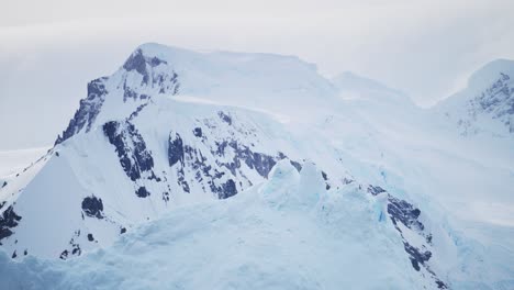 Antarctica-Winter-Mountains-Landscape,-Dramatic-Moody-Blue-Mountain-Scenery-with-Atmospheric-Mood-and-Atmosphere-on-Antarctic-Peninsula,-Snow-and-Ice-Covered-Winter-Icy-Snowy-Mountain-Peaks