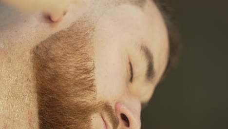 the barber carefully shaves the client's beard using a special shaving razor