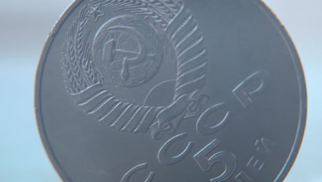 hyper macro shot of an old metal russian 5 ruble coin, cccp sssr symbol, vintage money, cinematic 4k video pan left