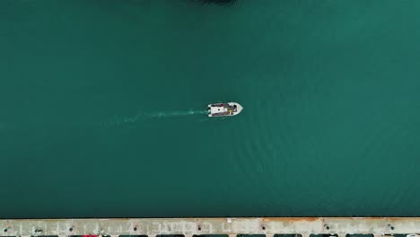 top-down shot of a small scientific boat heading out to conduct research in sete