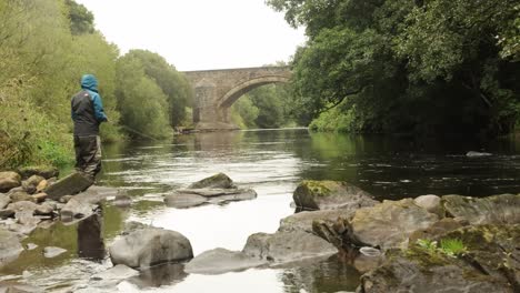 Hand-held-shot-of-a-flyfisherman-casting-into-a-slow-moving-section-of-a-river