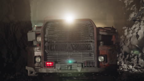 heavy machinery with bright lights operates in dark mine