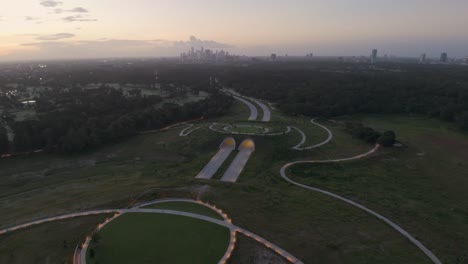 volando sobre el túnel y el parque de memorial drive al amanecer, con vistas hacia el horizonte de la ciudad de houston