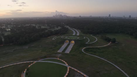 flying over memorial drive tunnel and park at dawn, with view towards houston city skyline