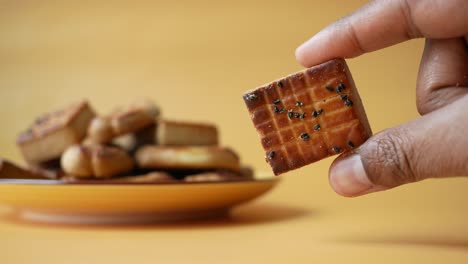 close-up of a person holding a sesame seed biscuit