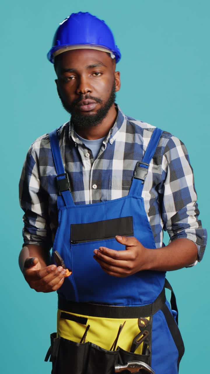Vertical video: Dizzy construction worker feeling light headed in studio