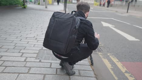 videographer on location in a city venue filming people crossing road