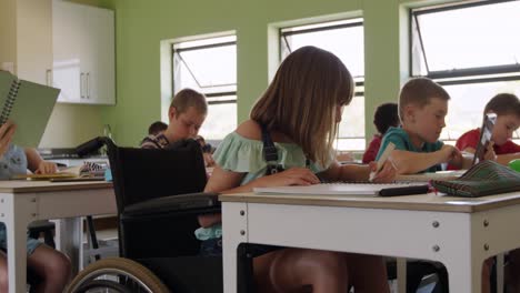 Niña-Con-Discapacidad-Física-Dibujando-En-Su-Cuaderno-En-La-Clase.