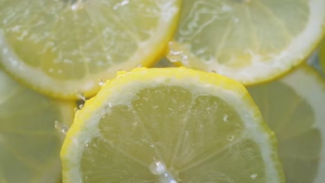 Topdown-view-of-Lemon-slice-spinning-with-fresh-water-splashing,-slow-motion-shot