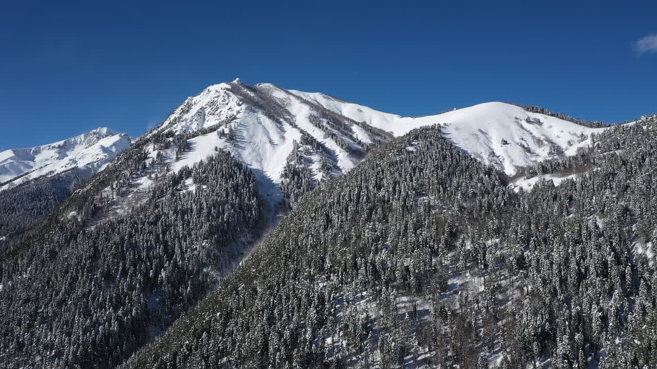 Volo aereo tra le nuvole di montagna sopra splendide vette innevate e ghiacciai.