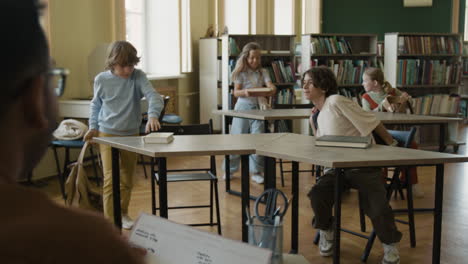 children and students in a school library or classroom, interacting and preparing for lessons