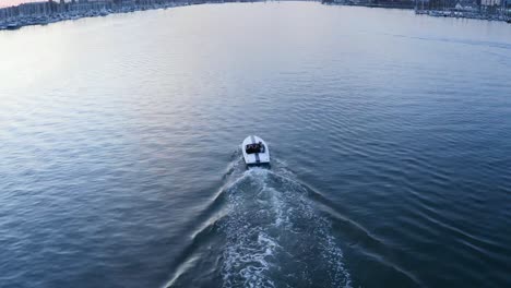 a fast speedboat passes before the setting sun in this brilliant bay water reflection