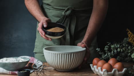 crop cook adding cane sugar to pastry batter