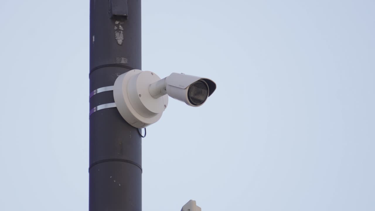 Telecamera di sorveglianza CCTV esterna. Rappresenta la supervisione governativa, la sicurezza pubblica e i moderni sistemi di sicurezza urbana. Metafora visiva per la sorveglianza statale, le preoccupazioni sulla privacy e il monitoraggio costante.
