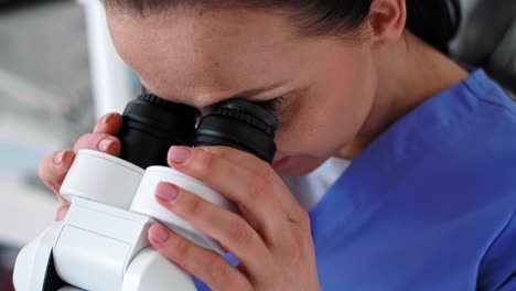 primer plano del dentista mirando a través del microscopio dental